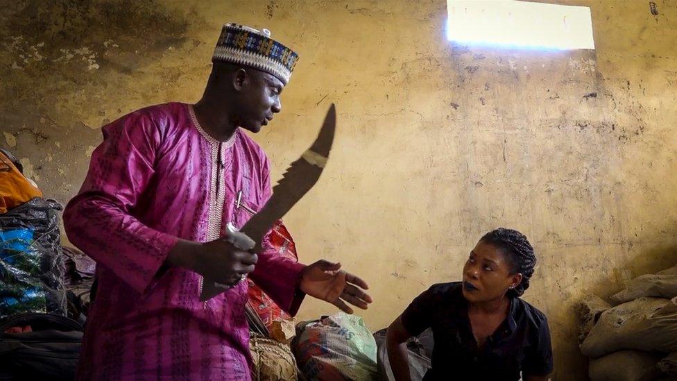 Man showing Ruona Meyers a sword seized from a drugs gang