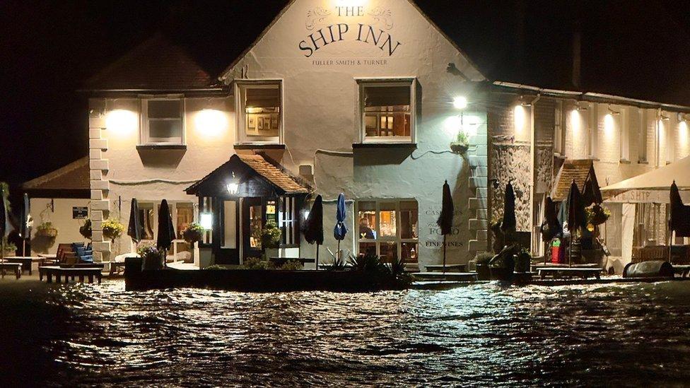 Flooding around a pub, with the roads submerged under water.