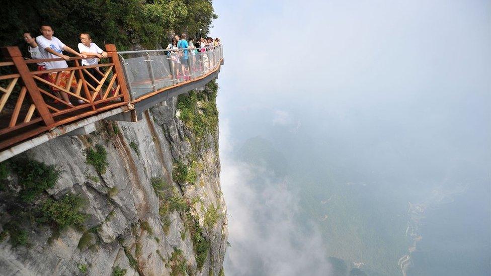 People walk around a glass walkway in Tianmen Mountain in Zhangjiajie National Forest Park, Hunan, China (1 August 2016)