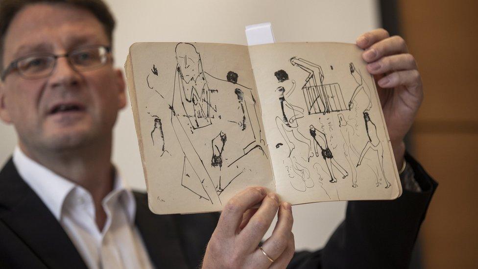 Stefan Litt, from the National Library of Israel, holding up a book of Kafka's drawings