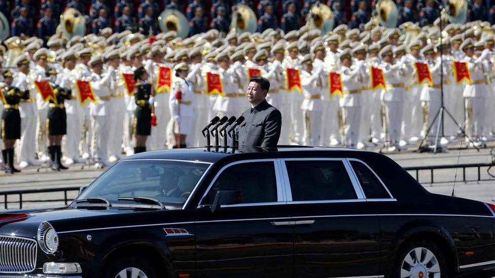 Chinese President Xi Jinping stands in a car to review the army during a parade commemorating the 70th anniversary of Japan's surrender during World War II