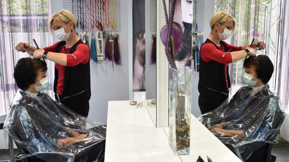 A hairdresser cuts a client's hair in Puchheim, Germany