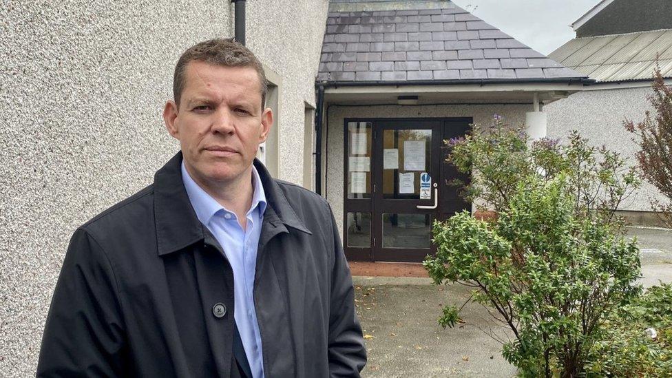 Llun o Rhun ap Iorwerth tu allan i feddygfa yng Nghaergybi