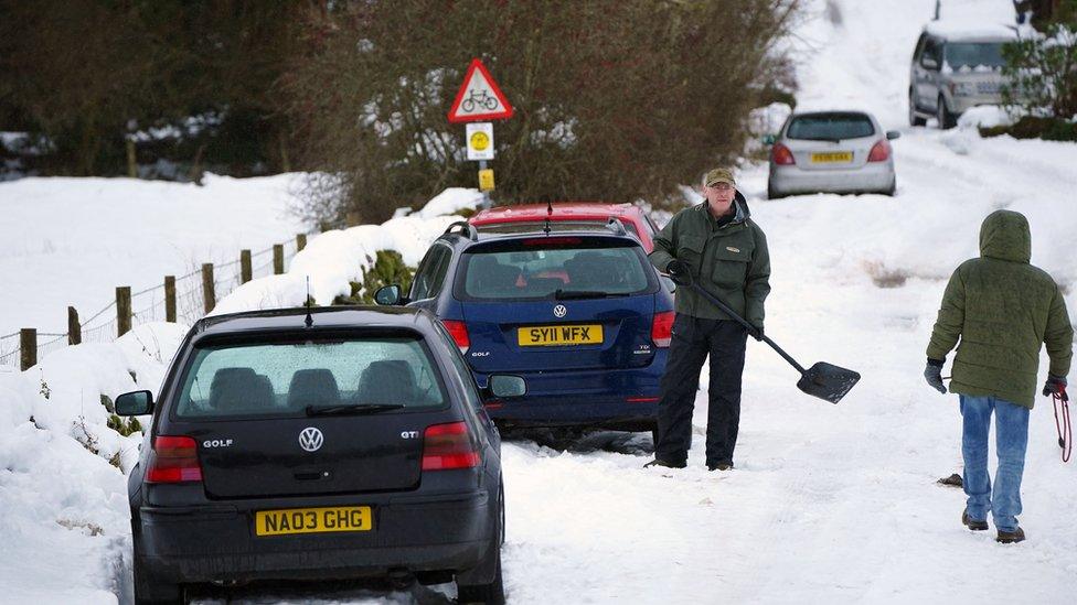 People clearing snow on roads in Cumbria