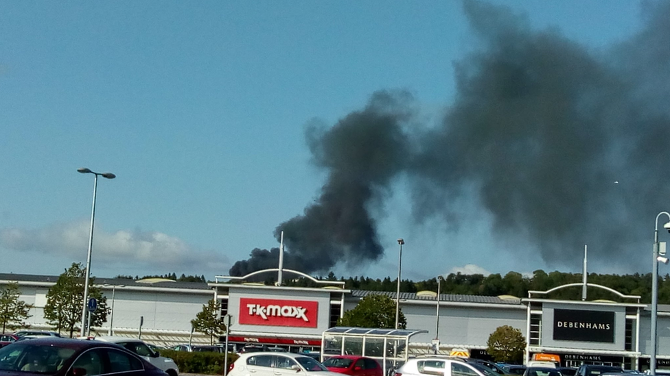 Smoke from the fire behind shops