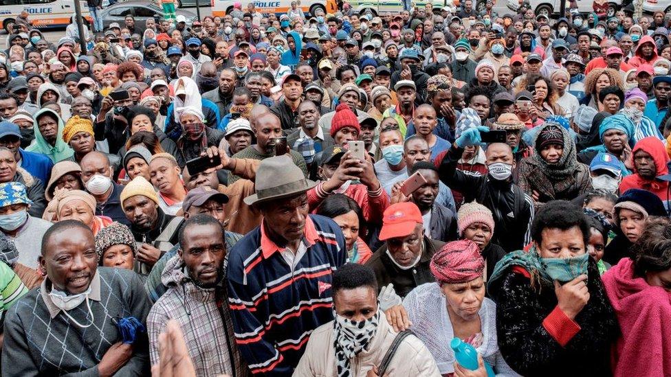 Informal vendors gather in front of a municipal office building in Braamfontein, Johannesburg, on April 8, 2020, as they try to obtain a permit for working during the 21 days national lockdown that started on March 27, 2020, in an attempt to halt the spread of the COVID-19 coronavirus outbreak