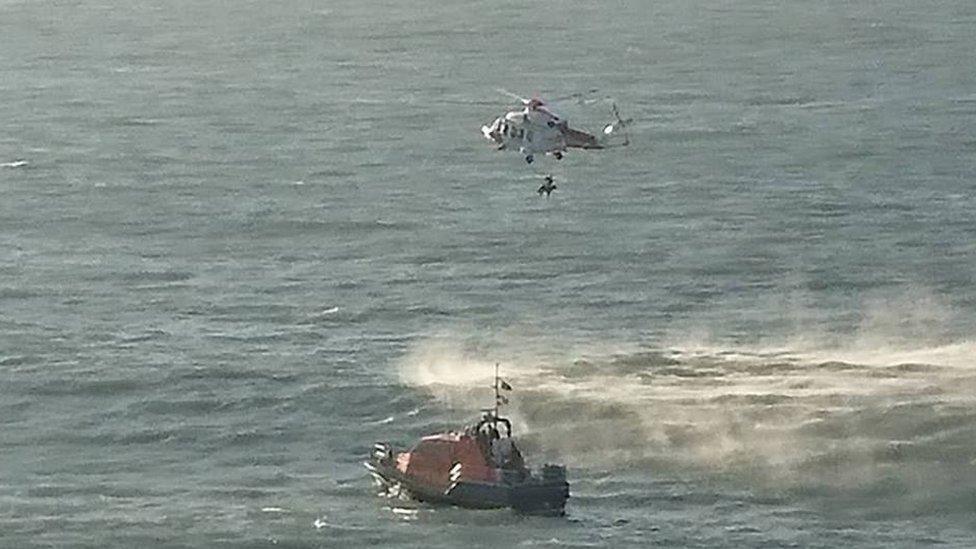 Helicopter winching a man to safety