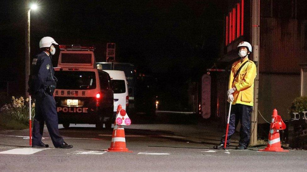 Police officers stand guard near the scene of a standoff after Wednesday's attack