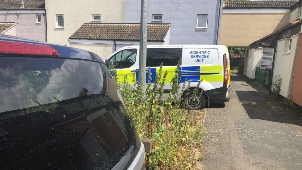 Police vehicle outside house after fire