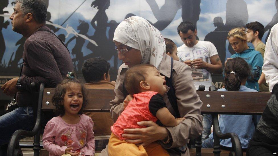 A child cries as hundreds of people tried to board a train to take them out of Hungary