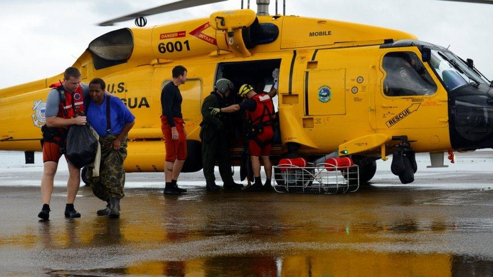 Evacuees leave a US Coast Guard helicopter after being rescued from flooding due to Hurricane Harvey in Houston