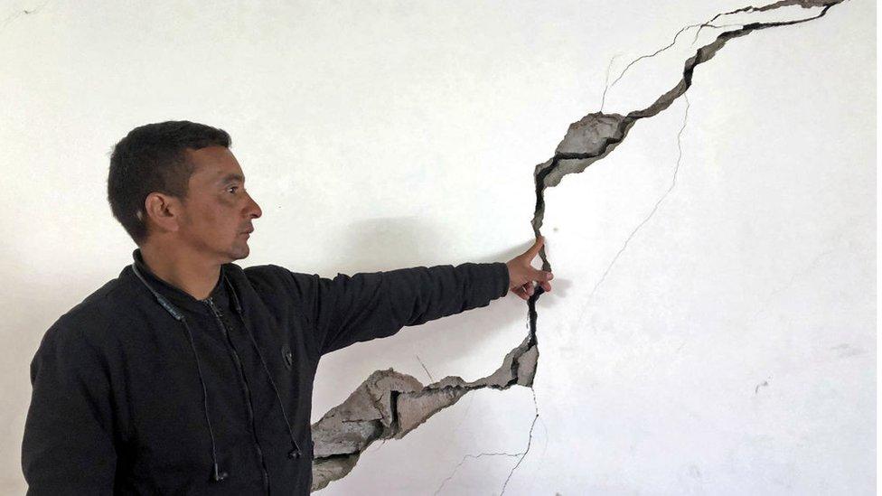 A resident shows a crack on the wall of his house at Joshimath in Chamoli district of India's Uttarakhand state on January 8, 2023.