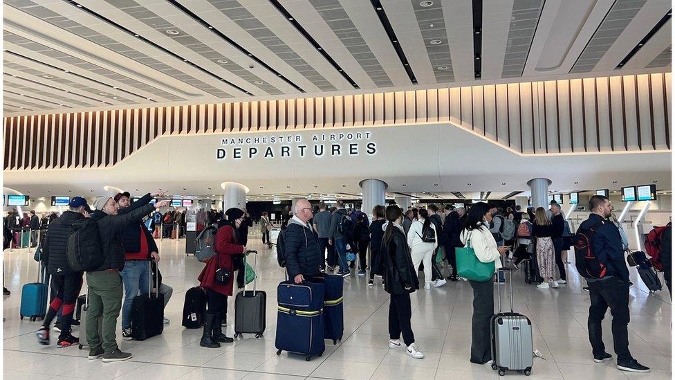 Passengers queue for security screening in the departures area of Terminal 2 at Manchester Airport in Manchester