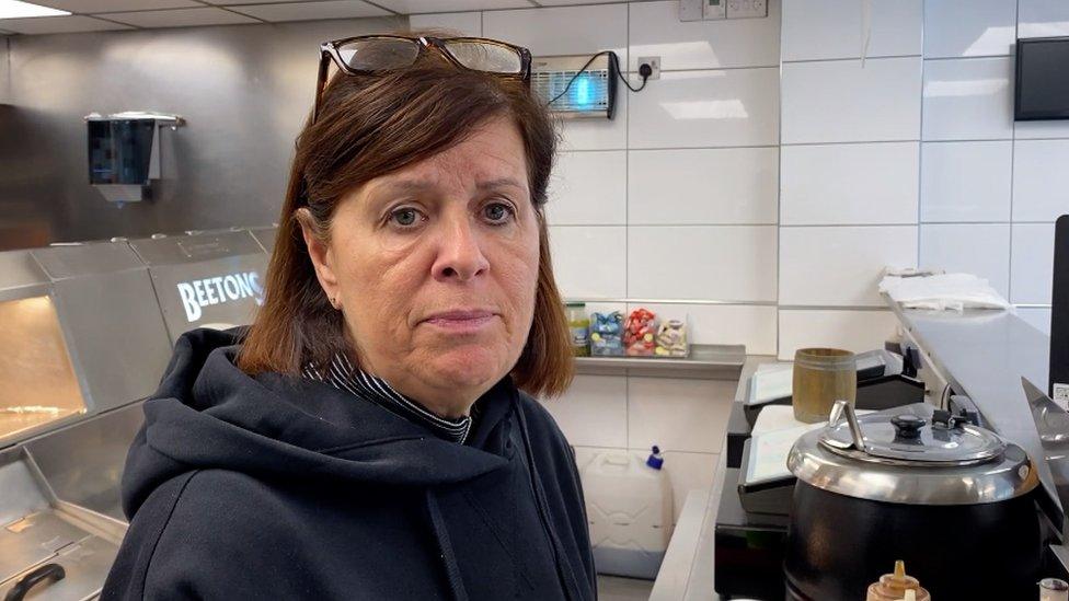 Woman behind the counter in a fish and chip shop