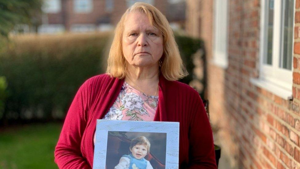 Joyce Ellison with photograph of her son as a toddler