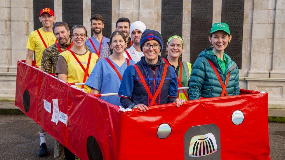 Jackie Scully in a bus driver outfit with nine friends in costume