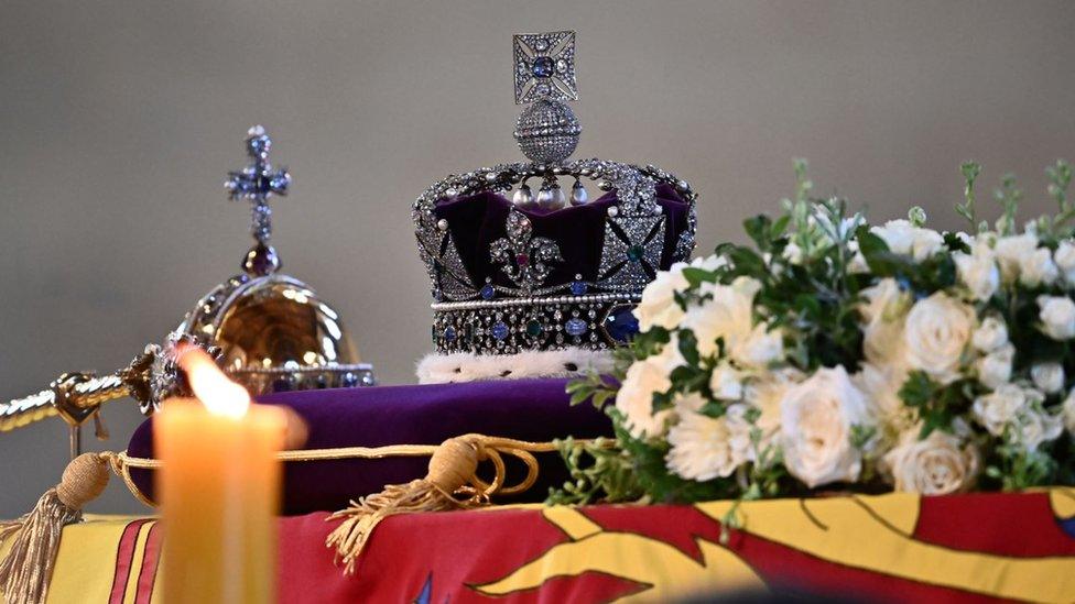 Crown, sceptre, candle and flowers on Queen's coffin