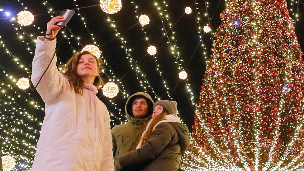 Ukrainians take a selfie with Kyiv's main Christmas tree