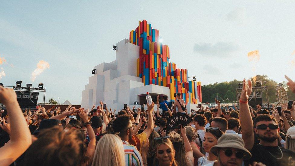 Festival-goers dancing near a stage