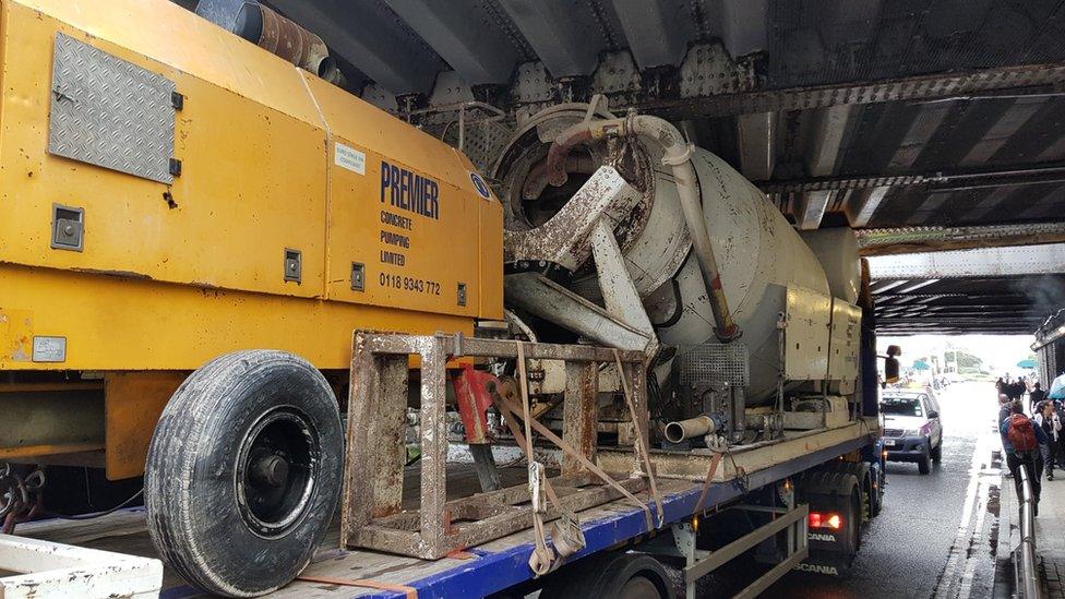 Lorry wedged under bridge