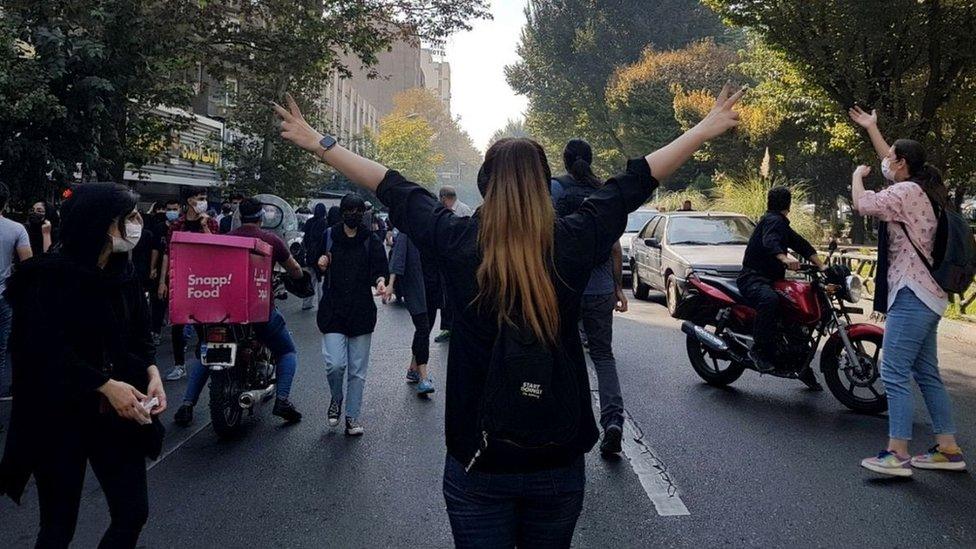 Women without headscarves block a road during a protest in Tehran, Iran, (1 October 2022)