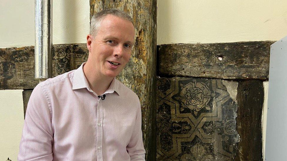 Andrew standing in front of a Tudor painting