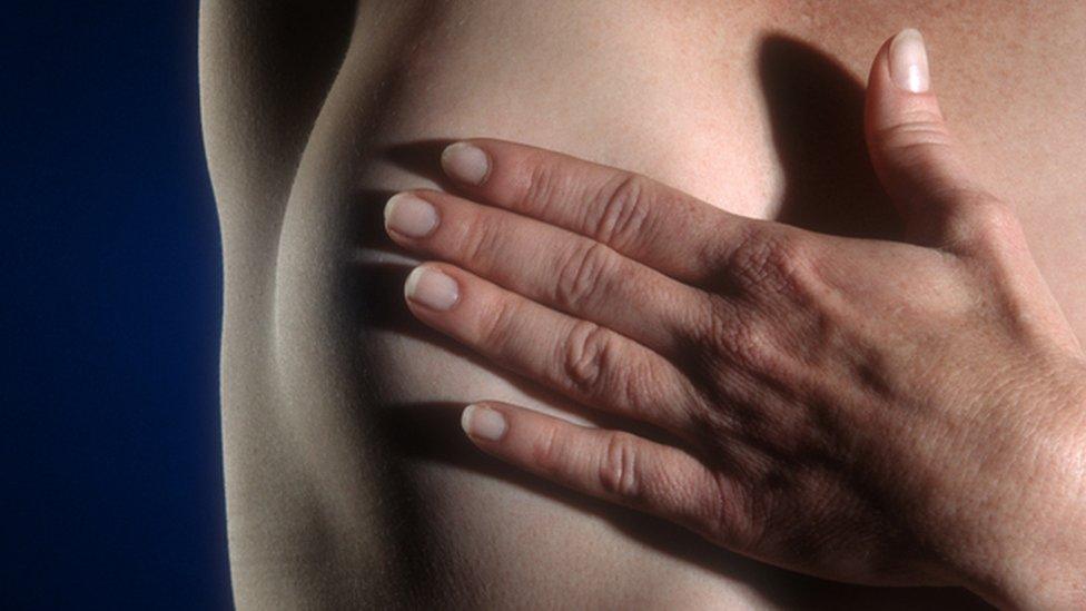 Woman examining her breast