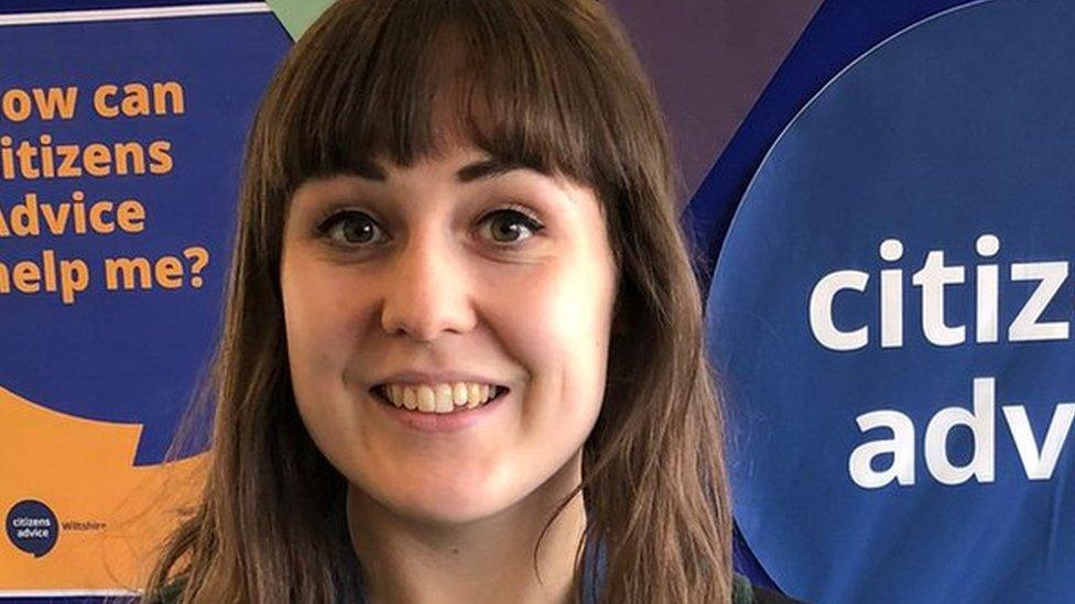 A women standing in front of a sign for citizens advice