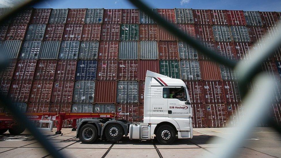 Lorry passing shipping containers