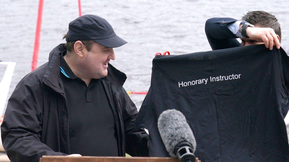 Peter Kay is given a shirt with the words Honorary Instructor on it