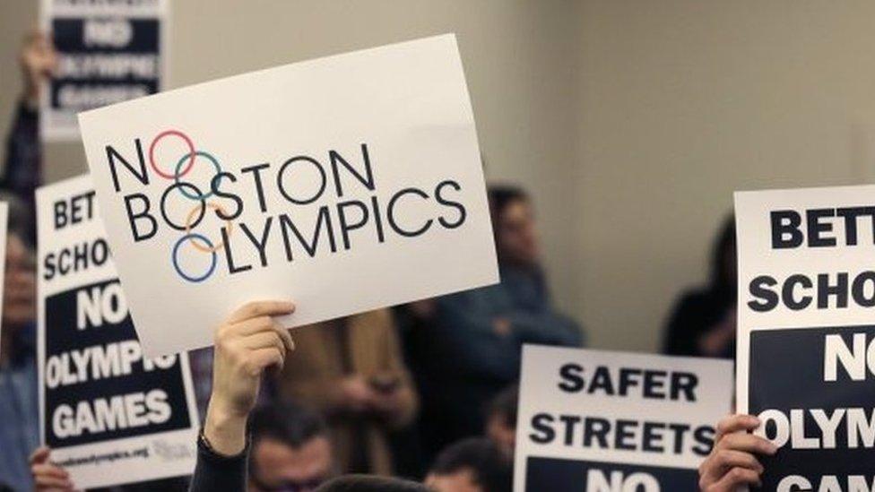 People hold up placards against the Olympic Games coming to Boston, during the first public forum regarding the city's 2024 Olympic bid, in Boston. 5 Februay 2015