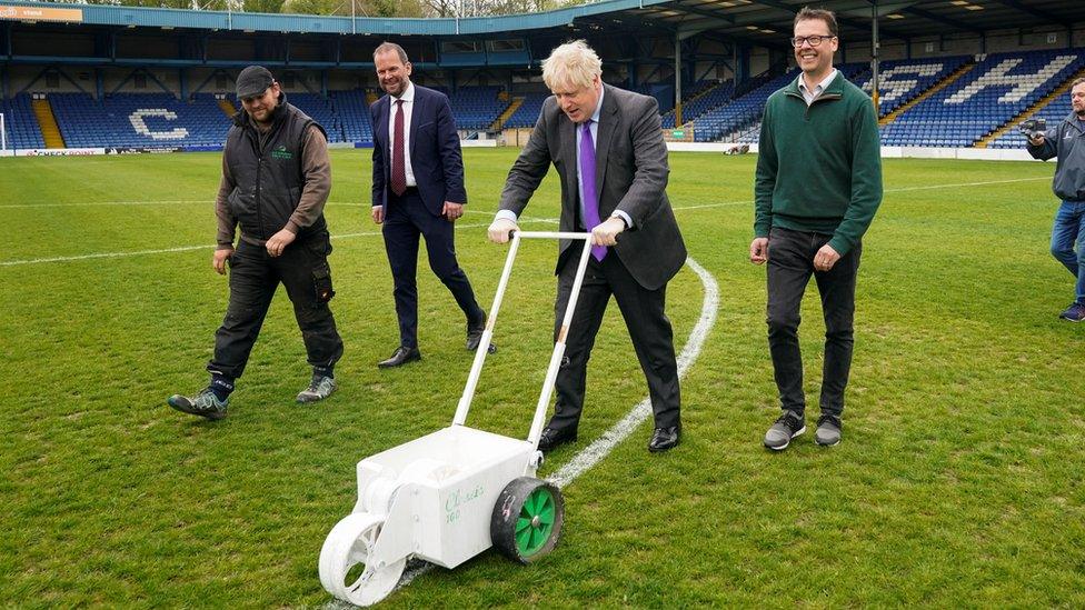 Boris Johnson painting lines at Bury's Gigg Lane stadium