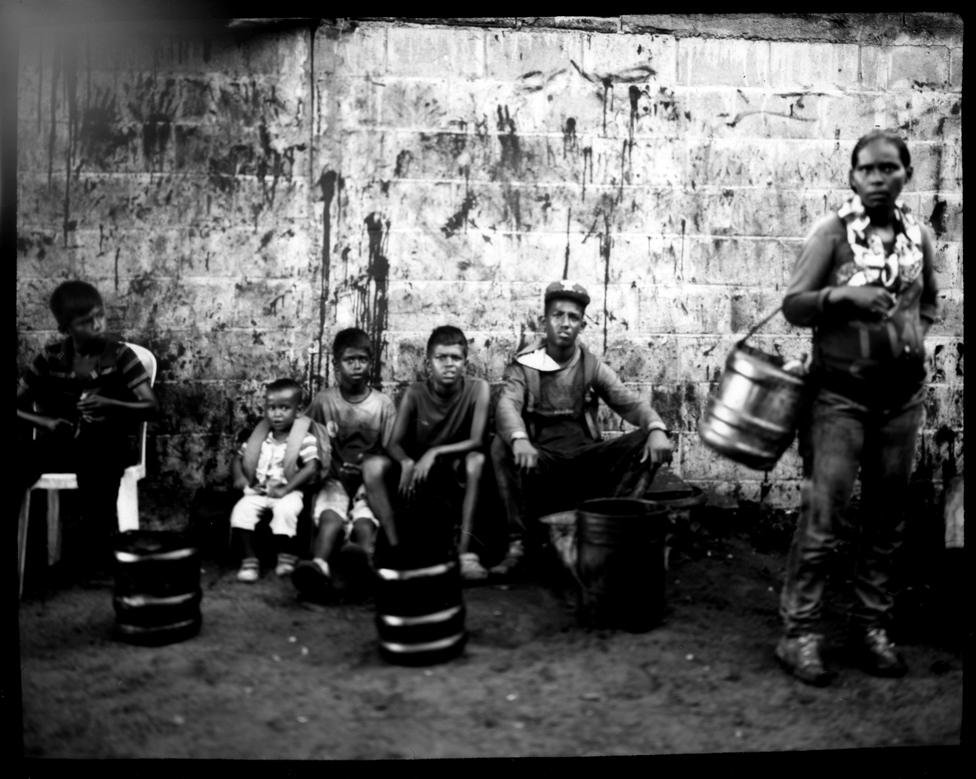 Villagers take a break from cleaning oil off freshly harvested crabs from Lake Maracaibo, in Punta Gorda, Cabimas, Venezuela.