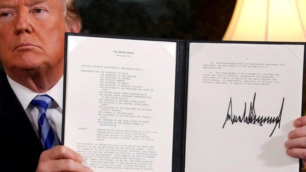 US President Donald Trump holds up a proclamation declaring his intention to withdraw from the JCPOA Iran nuclear agreement after signing it in the Diplomatic Room at the White House in Washington on 8 May 2018.