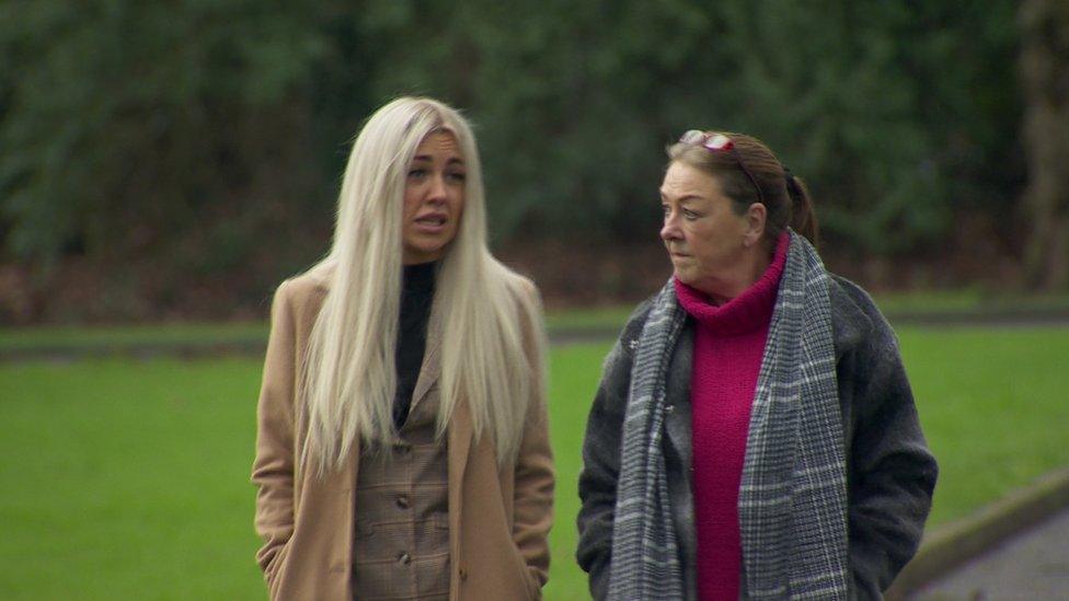 Lucy and her mum, Jane, walking in a park