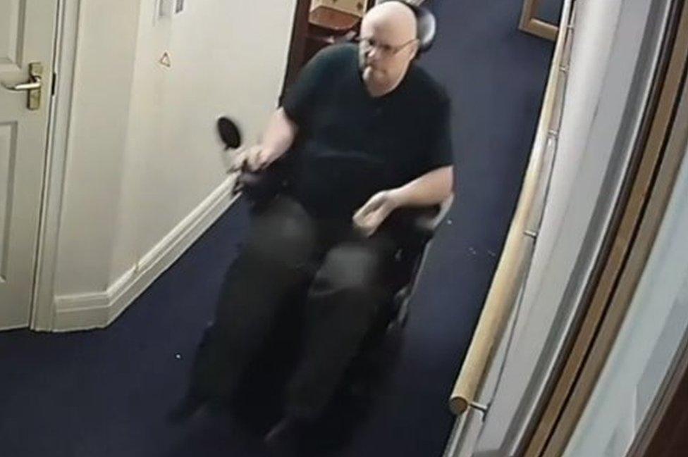 Still from CCTV of Ansbro in wheelchair on his way to Jane's flat