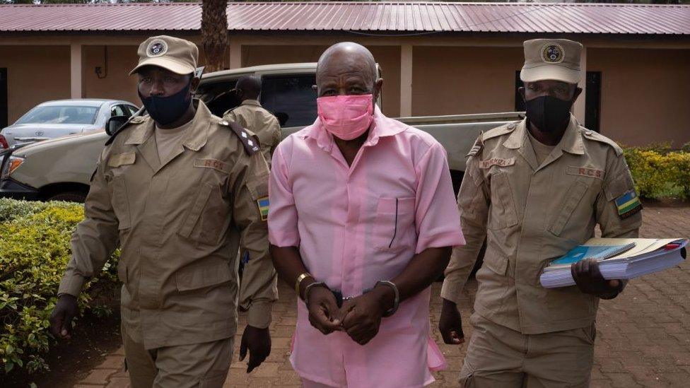 "Hotel Rwanda" hero Paul Rusesabagina (C) in the pink inmate's uniform arriving at Nyarugenge Court of Justice in Kigali, Rwanda, on October 2, 2020, surrounded by guards of Rwanda Correctional Service (RCS).