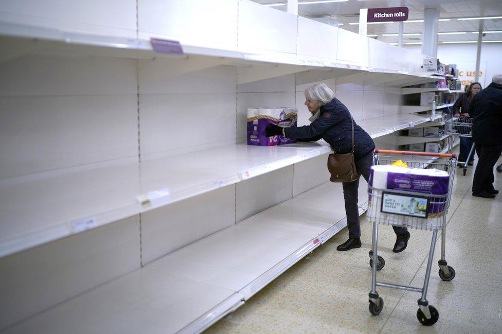 A senior citizen gets the last pack of toilet rolls at Sainsbury's Supermarket in Northwich, United Kingdom