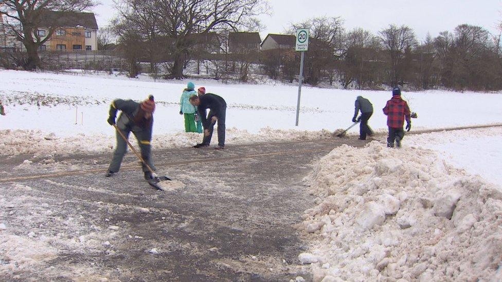 People out clearing snow in Bearsden