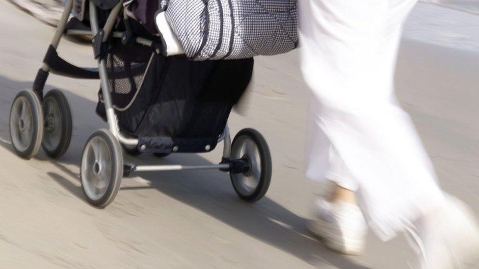 File photo of a young woman running with a pushchair.