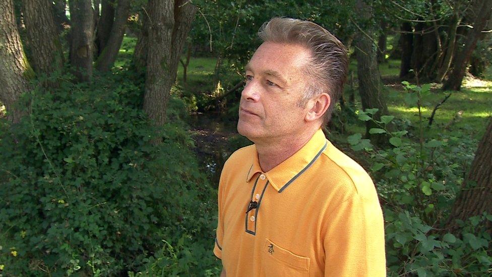 Chris Packham wearing yellow shirt in forest