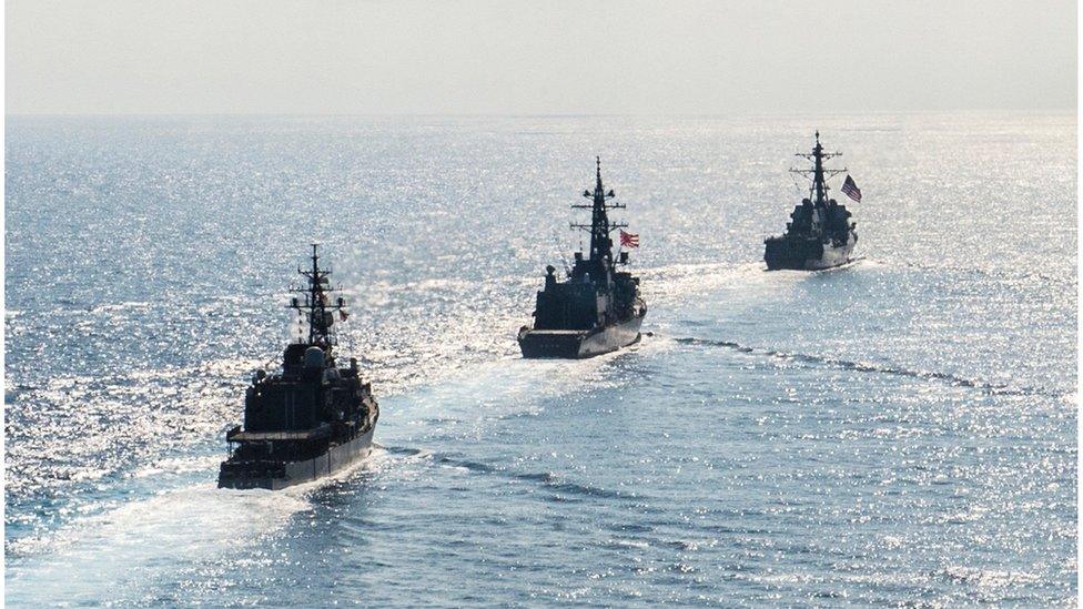 Arleigh Burke-class guided-missile destroyer USS Mustin (DDG 89) transits in formation with Japan Maritime Self-Defence Force ships JS Kirisame (DD 104) and JS Asayuki (DD 132) during bilateral training in South China Sea on 21 April 2015.