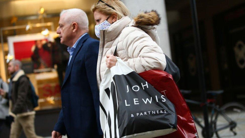 Woman carrying John Lewis shopping bag.