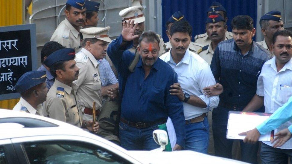 Indian Bollywood actor Sanjay Dutt (C) waves as he is escorted by officials from Yerwada Jail in Pune on February 25, 2016.