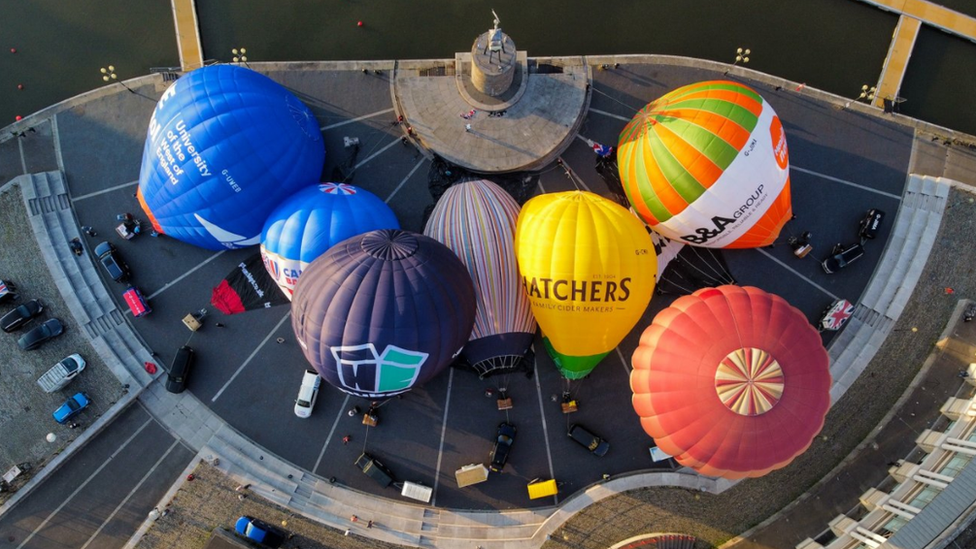 Hot air balloons inflate and tether from Bristol Harbourside