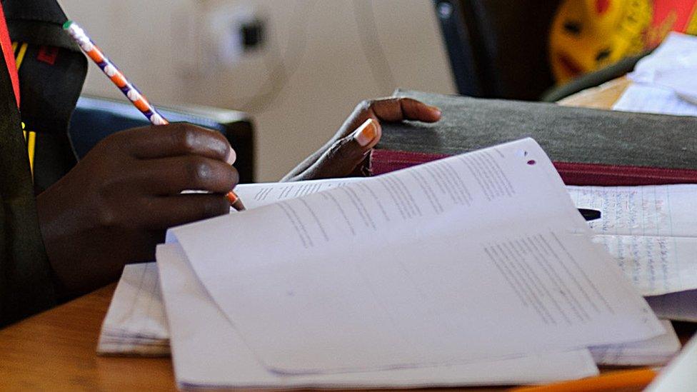 Young men and women studying for an exam on the edge of the Maasai Mara game reserve July 7, 2012