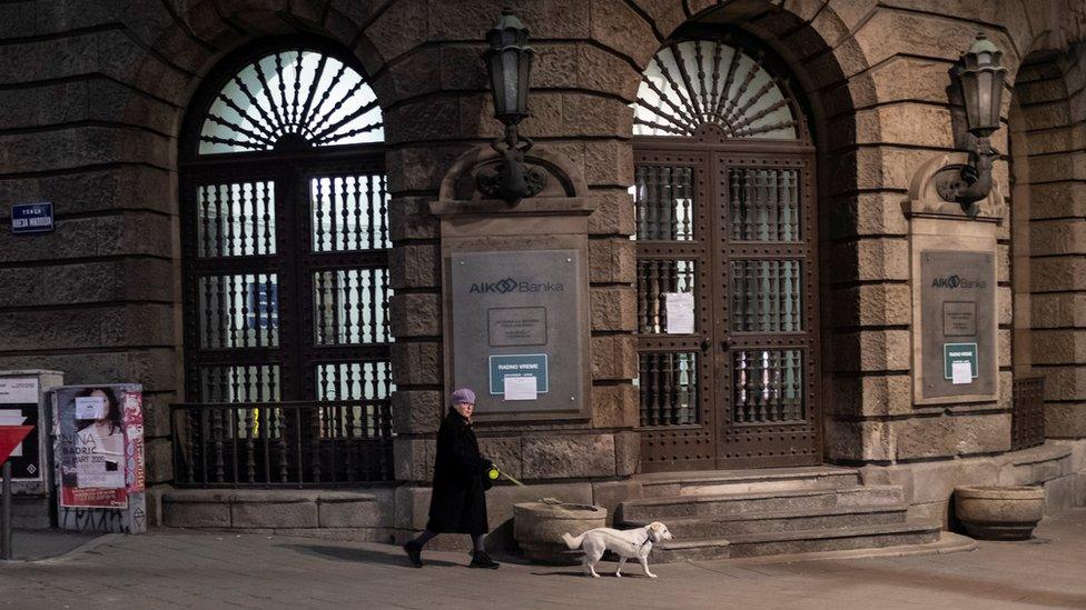 A woman walks her dog during a curfew imposed to prevent the spread of coronavirus disease in Belgrade