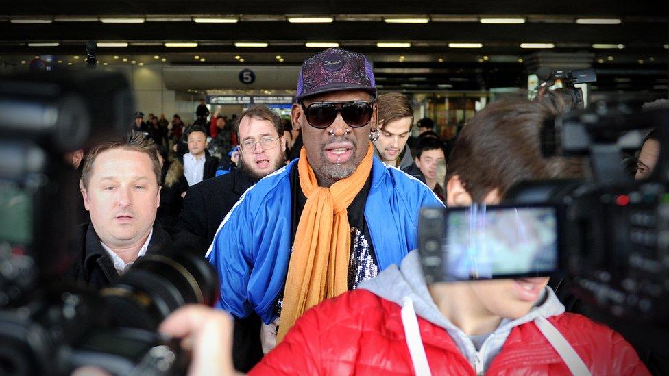 Canadian businessman Michael Spavor (L) walks with former US basketball player Dennis Rodman (C) after arriving from North Korea at Beijing International Airport on 13 January 2014.