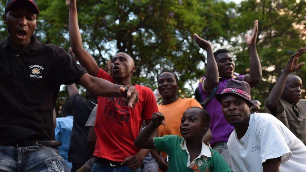 People celebrate in the streets of Harare, after the resignation of Zimbabwe's president Robert Mugabe on November 21, 2017