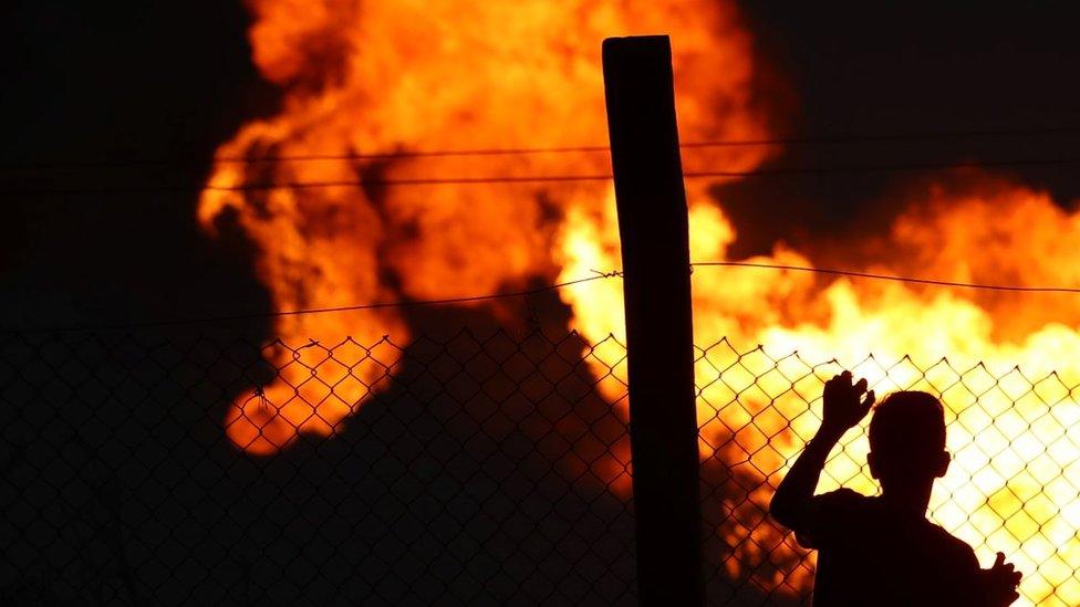 Child at fence line with flare behind